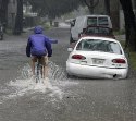 A man ride his bike through a flooded street... ABC NEWS
